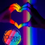 Picture of hands making a love heart with an LGBTQ rainbow theme.