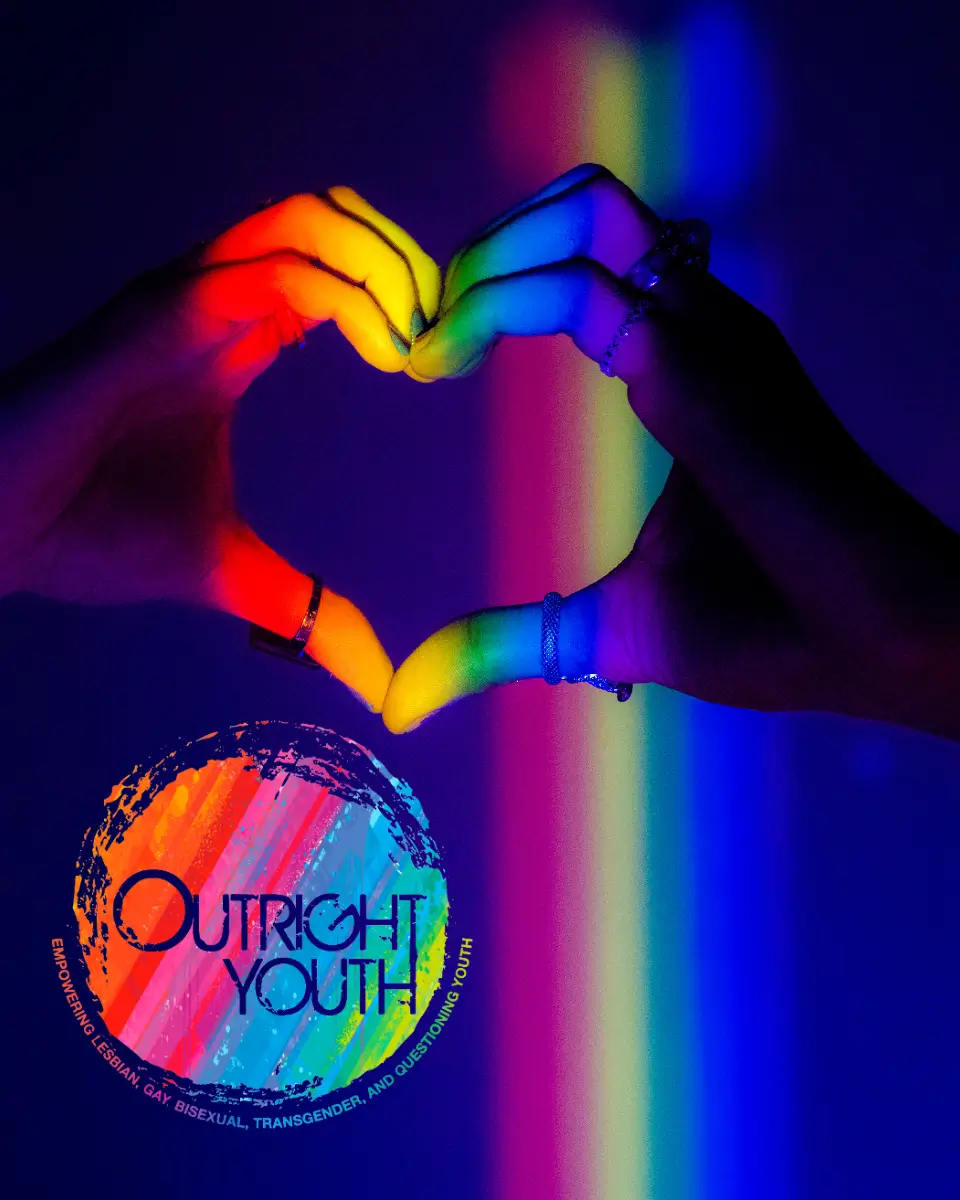 Picture of hands making a love heart with an LGBTQ rainbow theme. 